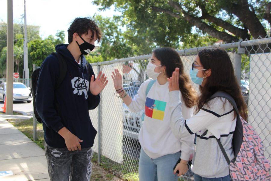 Students chat outside the Gables campus on Oct. 9, wearing masks on their first day back to school.