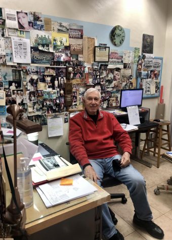 A smiling Mr. Finora sits in his office in front of a wall of old photos he has gathered throughout his time at Gables.