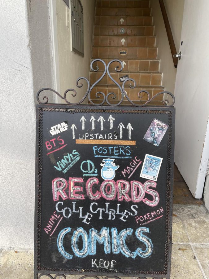 The entrance of the shop is marked by a colorful chalkboard sign.