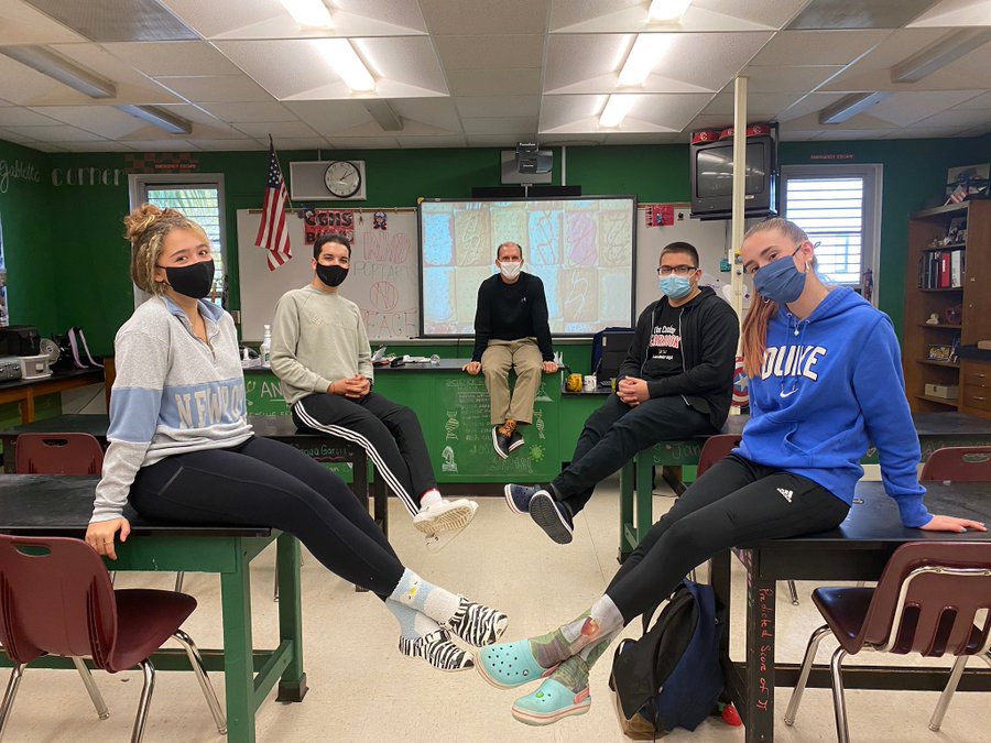 The 7th period class, with Mr. Molina in the center back, poses with their shoes on a Crocs Friday.