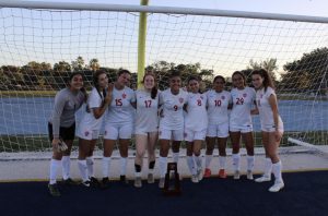 The Lady Cavaliers soccer team celebrates their 4-0 victory over Miami High with their district championship trophy