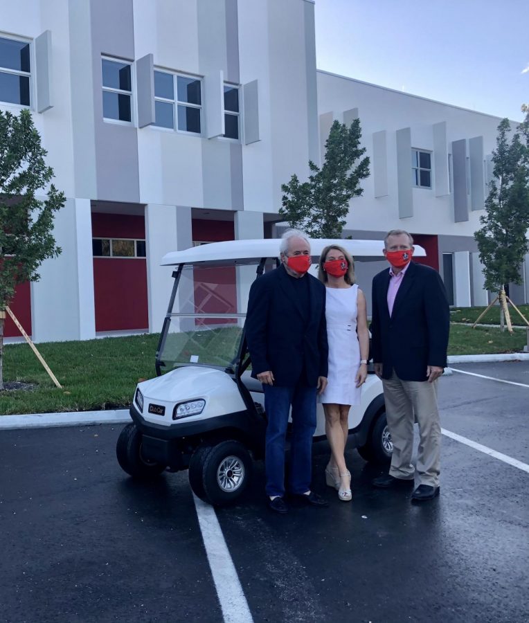Mr.Grossman (left), June Morris who is the founder of FOGH (middle), and Darrell Payne who currently holds the position as Chair of the organization (right), stand together in front of Gables' new ride. All alumni of the school, the trio show their school spirit by wearing Cavalier face masks. 