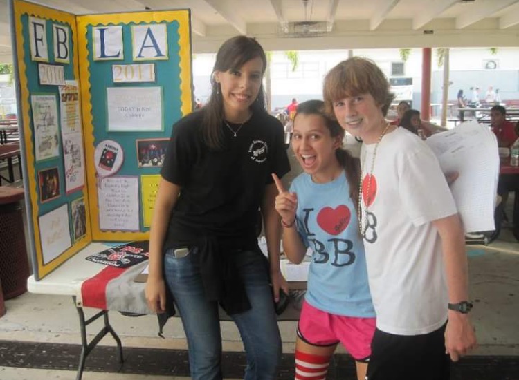 Wearing her Best Buddies shirt, Lazaro takes a picture in front of the Future Business Leaders of America stand.