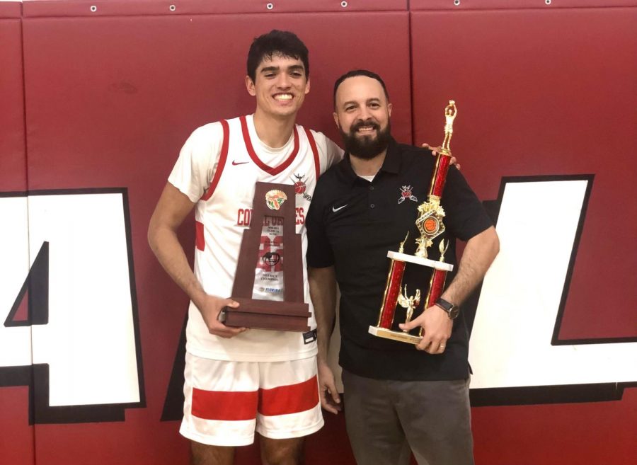 Mr. Govea stands with one of his star players as they hold up the district state champions trophy.