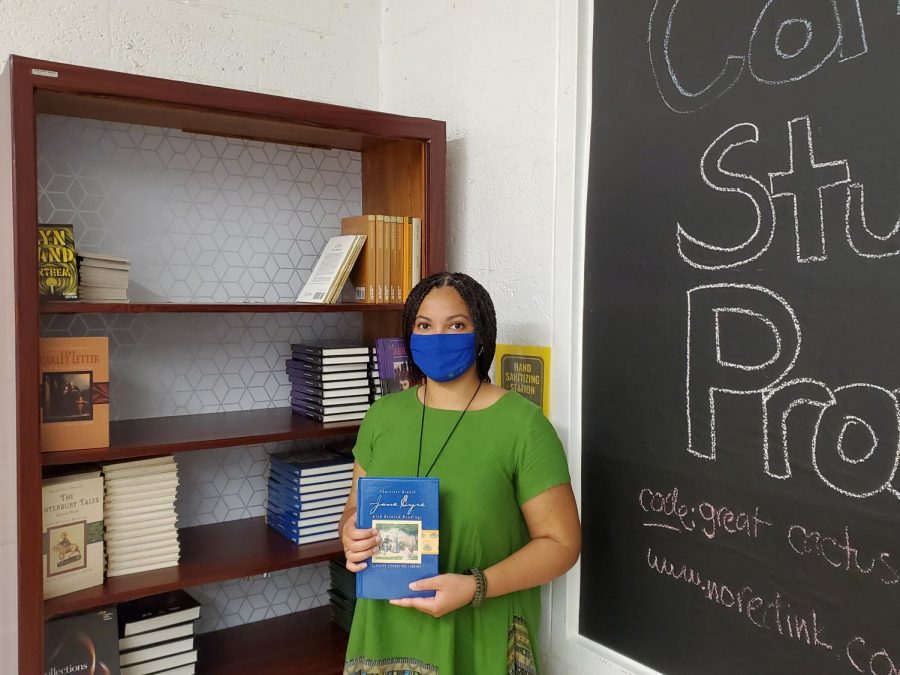 Ms. LeFebvre pictured by her bookshelf, holding a copy of “Jane Eyre,” her favorite novel.