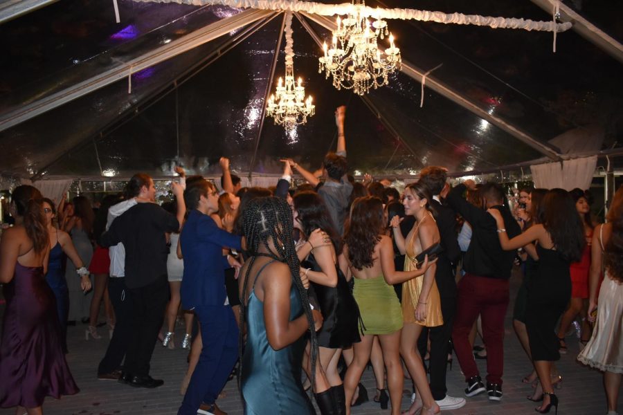 Students dancing under the chandelier.