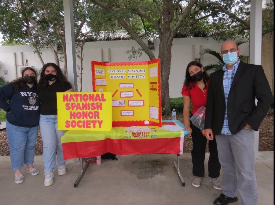 The National Spanish Honors Society board members stand alongside Mr. Sanchez as they work to recruit new students for the club.