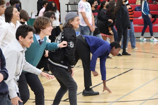 Students playing an intense game of Red Light Green Light as they try to make it to the other side of the court without being caught moving.