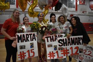 Standing alongside the Head Coach Lisa Nanninga (left) and Assistant Coach Katherine Mena (right), the four seniors celebrate their victory.