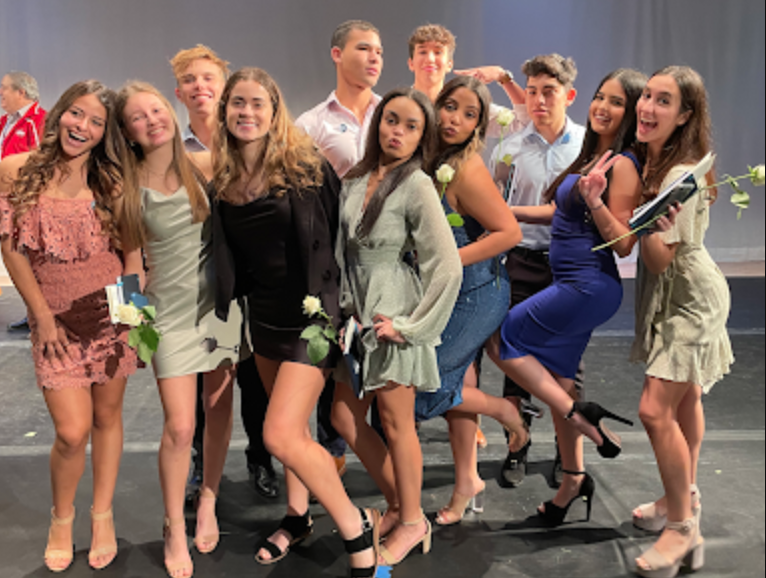 IB Juniors pose with their pins on stage.