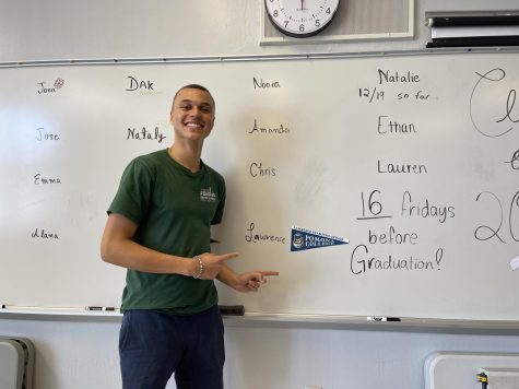 Lawrence Stampino-Strain standing proudly alongside his Pomona College flag in the Activities room.