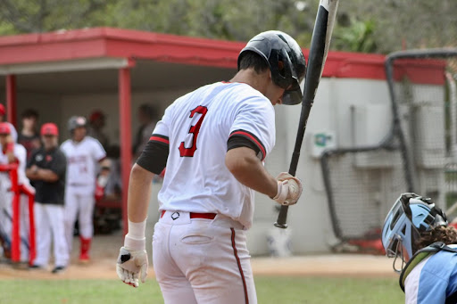 Looked upon by his teammates, Morina gets into his normal hitting routine while at home plate.