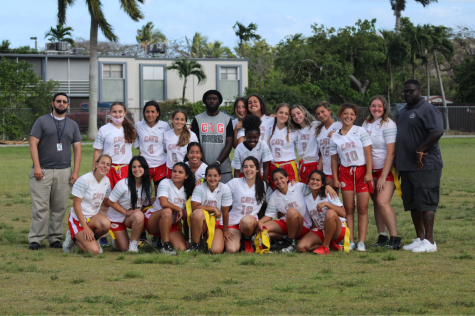 The girls flag football team joined by their coaches Coach Strachan and Coach Willy.