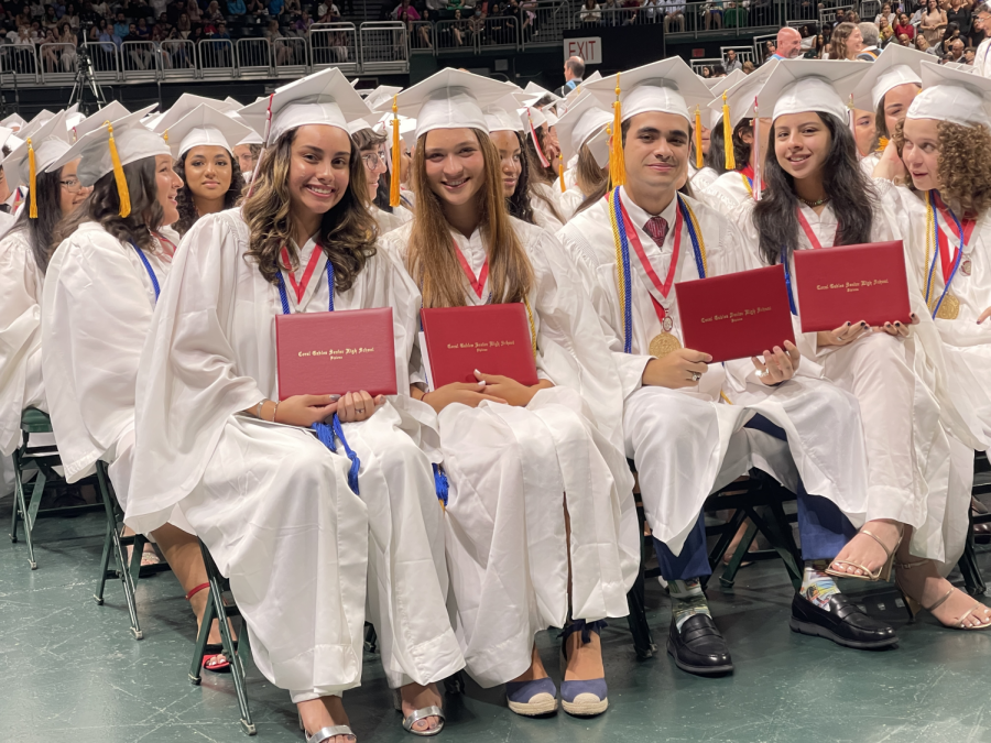 Graduates+gather+with+their+diplomas+in+hand+to+celebrate+their+four+years+at+Gables.