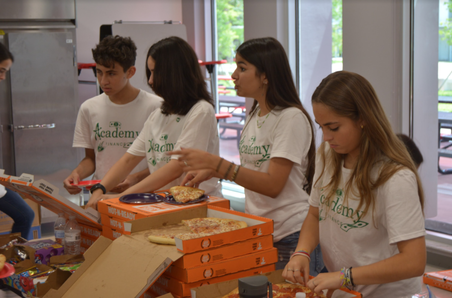 Volunteers and AOF board members, Sebastian Montoya, Maria Odio, Angelina Milan and Audrey Noval (left to right) assist in handing out slices of pizza to attendees.
