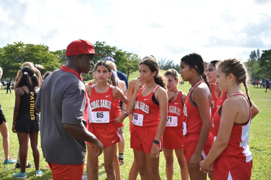 Coach Fotso gives the Varsity Girls Cross Country team a pep talk before they give it their all.