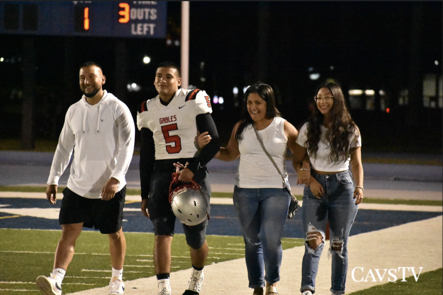 Senior Lucas Paez walking across the field with his family on senior night. 