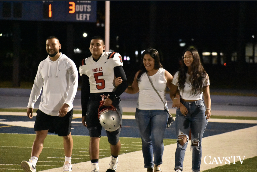 Senior+Lucas+Paez+walking+across+the+field+with+his+family+on+senior+night.+