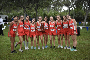 The girls cross country team poses with their District Runner-Up trophy.