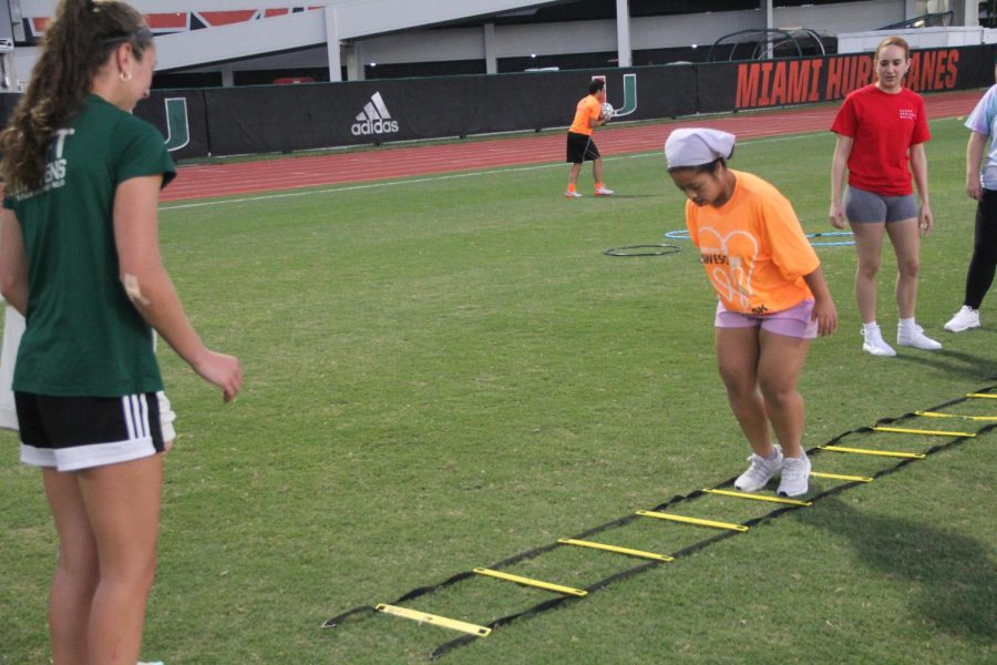 Among other activities like hula-hoop crossing, some participants did ladder jumping exercises before kicking a ball.