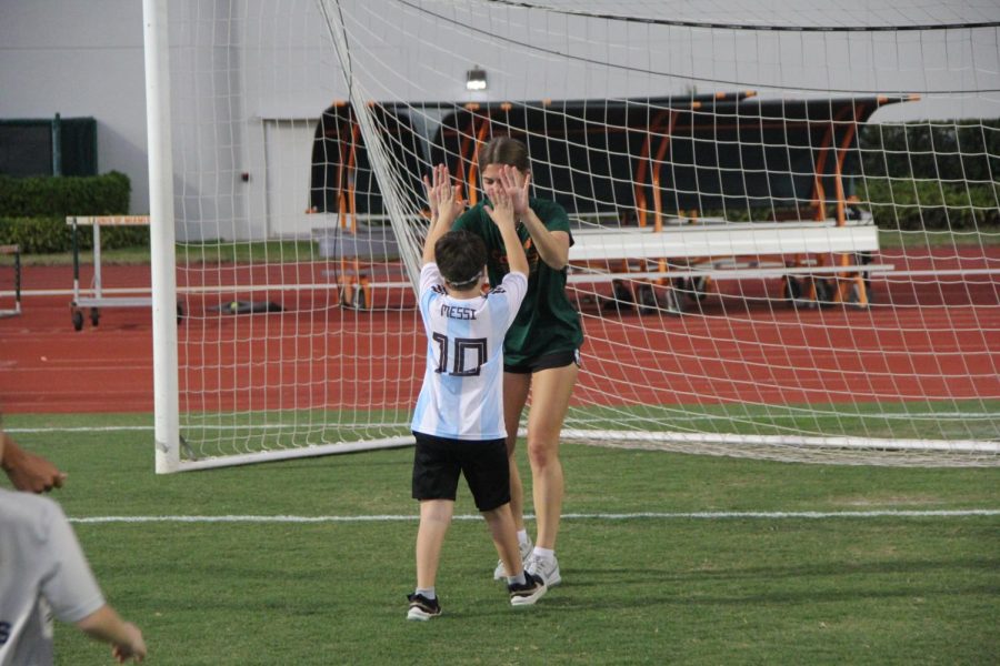 After scoring the goal, both participants from the soccer clinic celebrated the victory with a high-five.