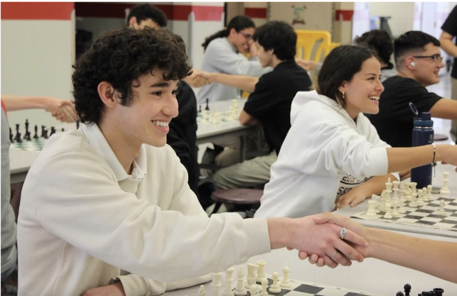 Students shaking hands as they prepare to play their opponents during the tournament. 
