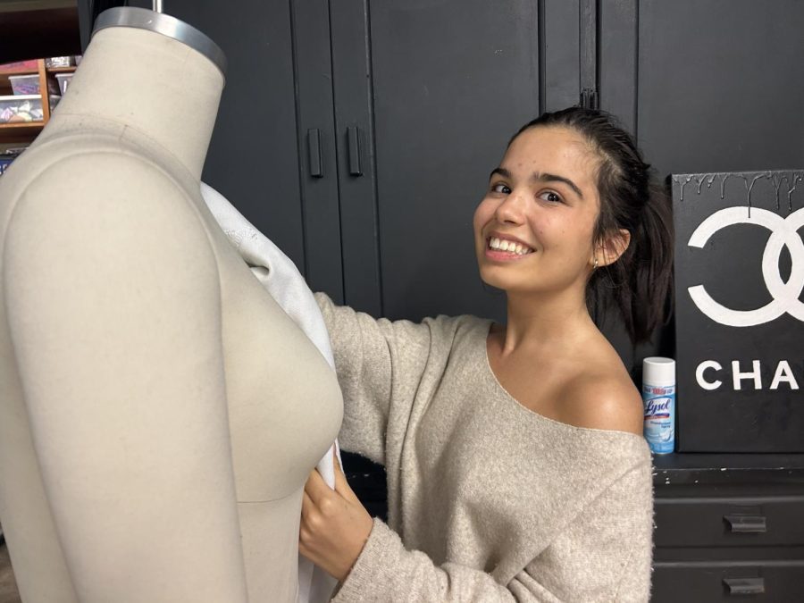 Senior Emma Palanque poses with a mannequin in Gabless fashion room before she sets her sights to FIT.