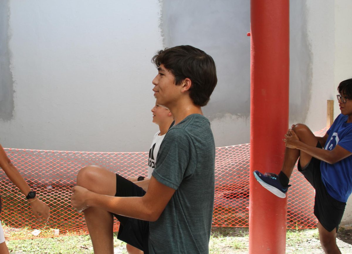Freshman Santiago Rodríguez completes dynamic stretches to help loosen his muscles before a run. 