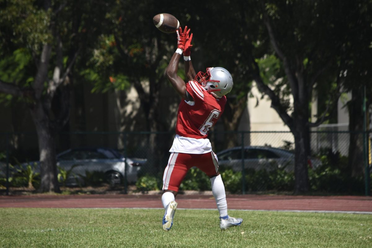Continuing to score touchdowns, junior wide receiver Zuri Winkfield brings his arms up high as he catches the ball.