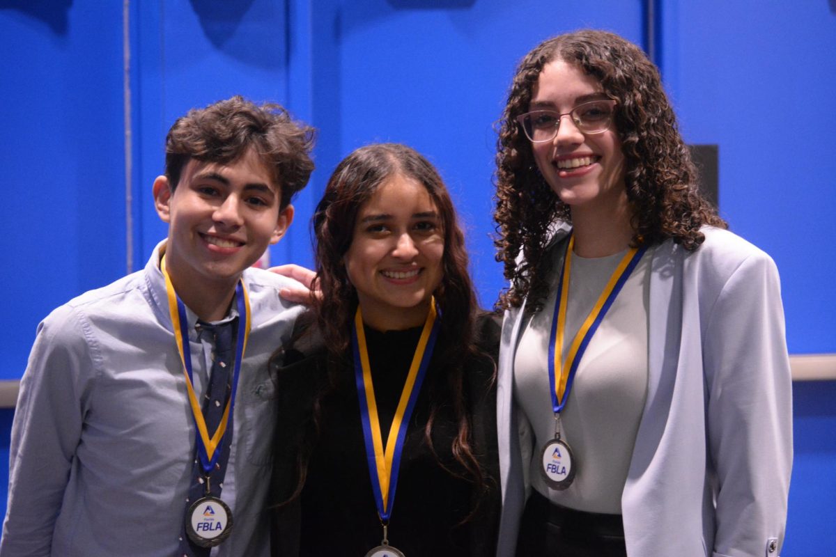 Alongside fellow FBLA members, co-president Balery Quiñonez poses proudly with her medal after a huge win in District 26.