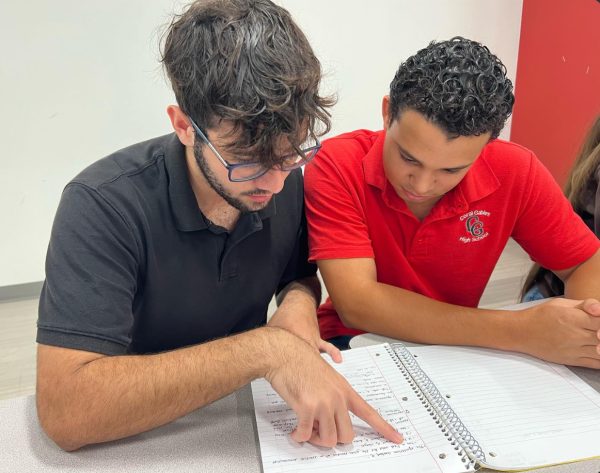 Tutoring after school, senior Brayan Mendoza teaches a student in their latest chemistry lesson.