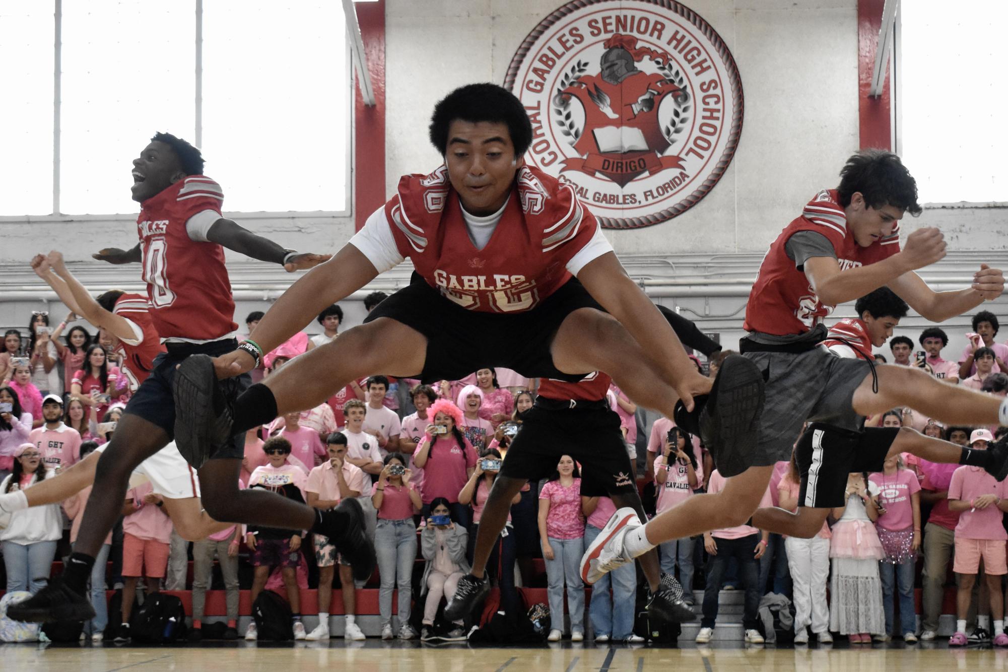 The football team perform an impressive cheer stunt, receiving applause from the crowd.