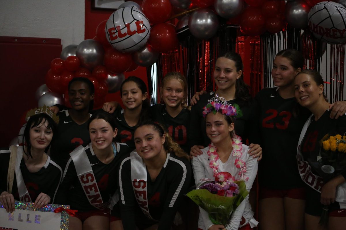 Gathering around, the girls varsity team poses for a picture honoring this special night alongside their beloved seniors.