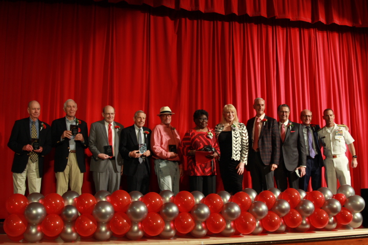 The+11+inductees+stand+with+their+plaques+on+the+auditorium+stage.+Each+one+was+recognized+for+their+achievements+and+outstanding+Cavalier+spirit.