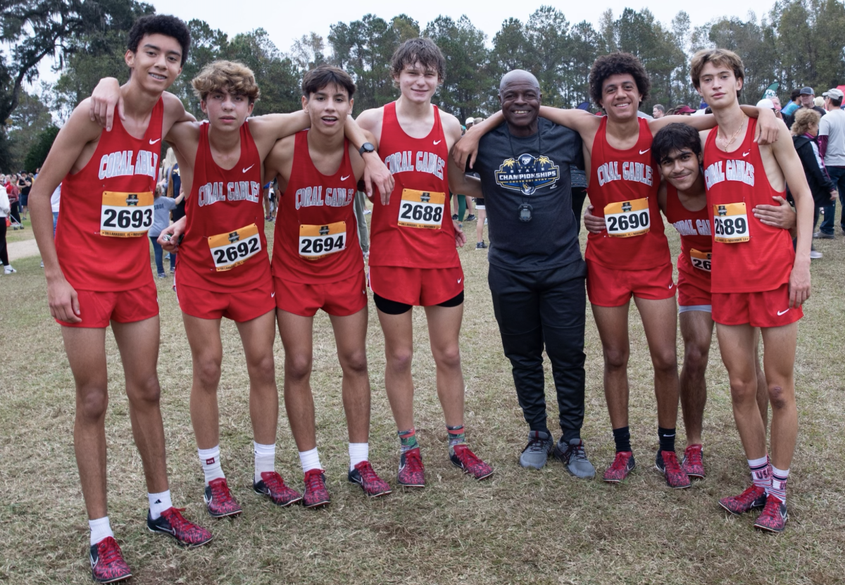 The boys cross country team poses with Coach Michel Fotso to one day remember the success of the 2023 season. 