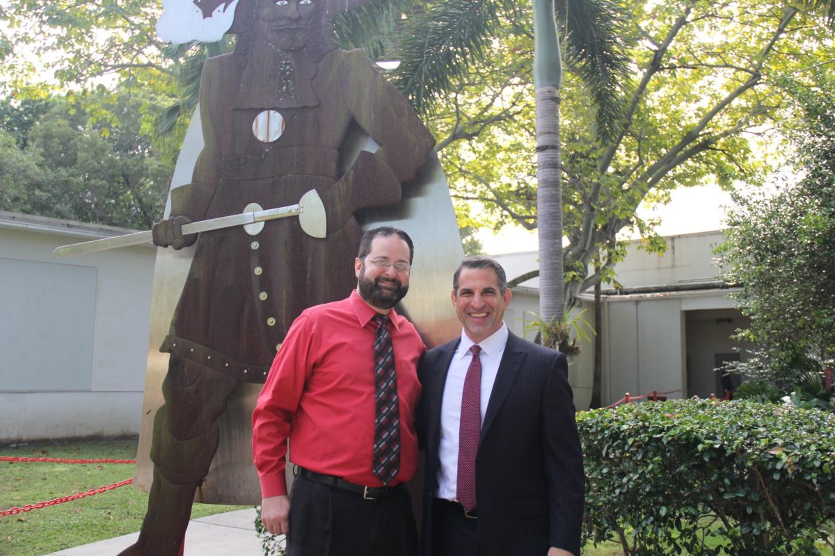 Standing in front of the original Cavalier statue, Mr. Haj spends his last moments as a Cavalier with principal Mr. Ullivarri.