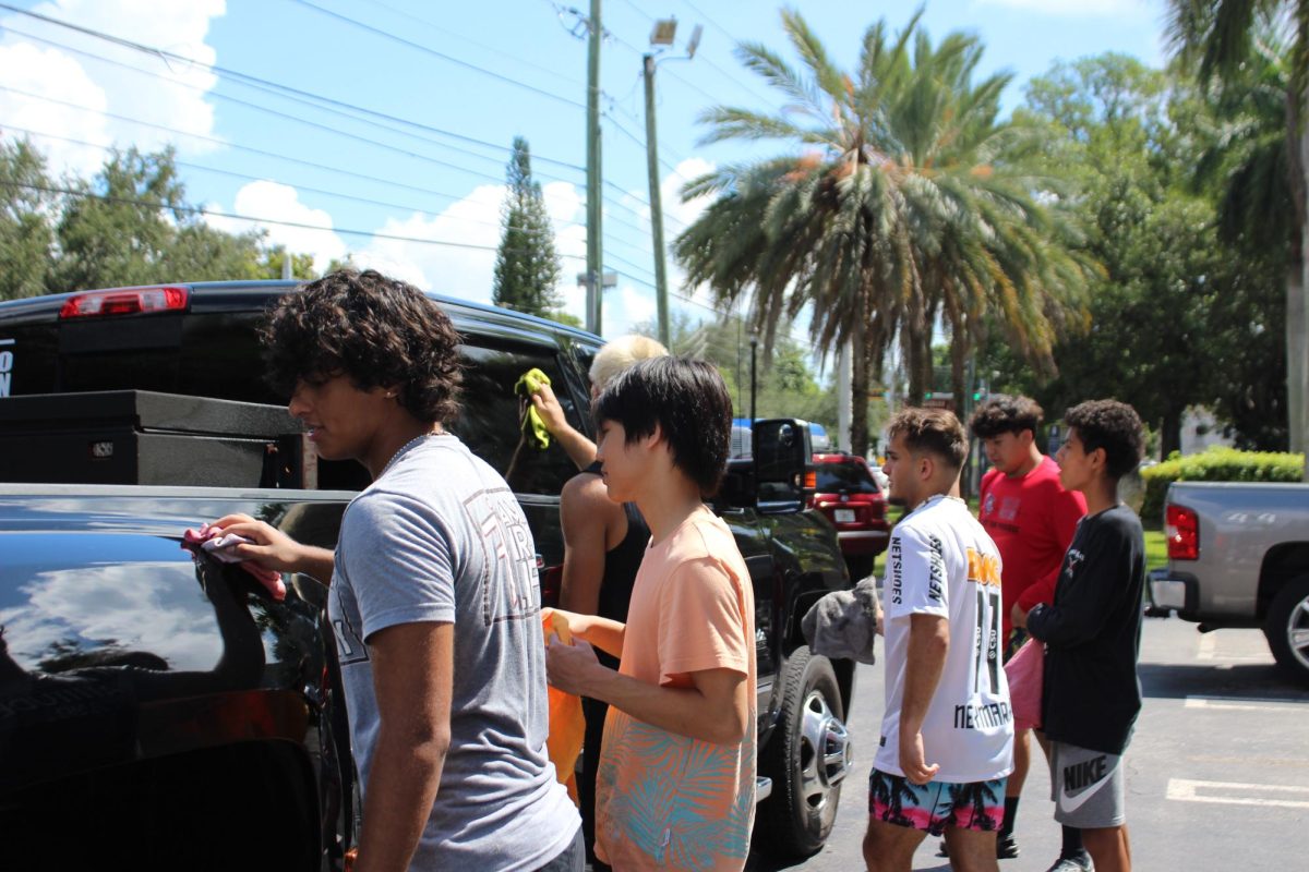 The wrestling team worked together to efficiently clean the cars of their many customers.