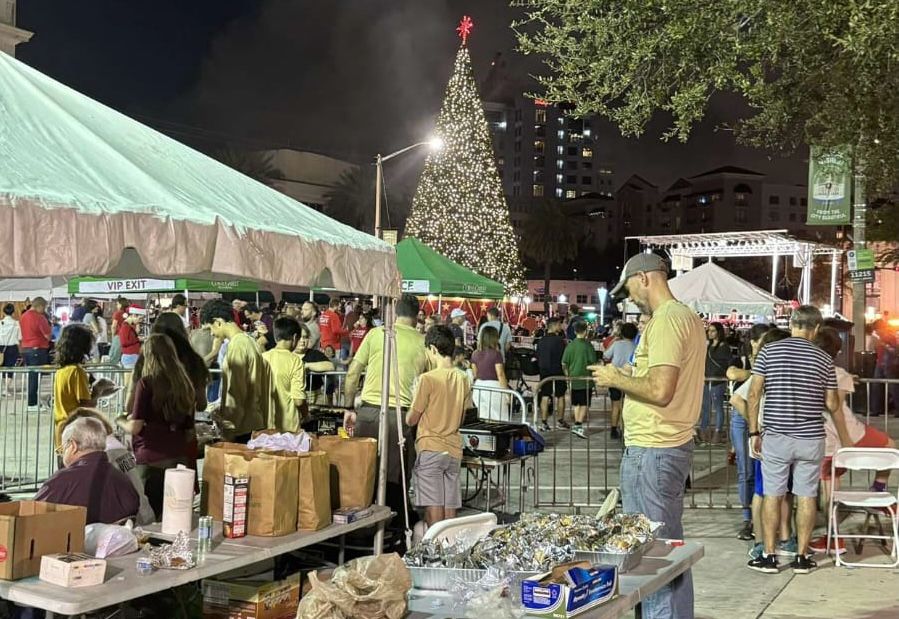 The Holiday Tree stands tall, a sight that many visitors waited for. In the meantime, those working Kiwanis Key Club Grilling Booth kept busy at the grill and took orders. 