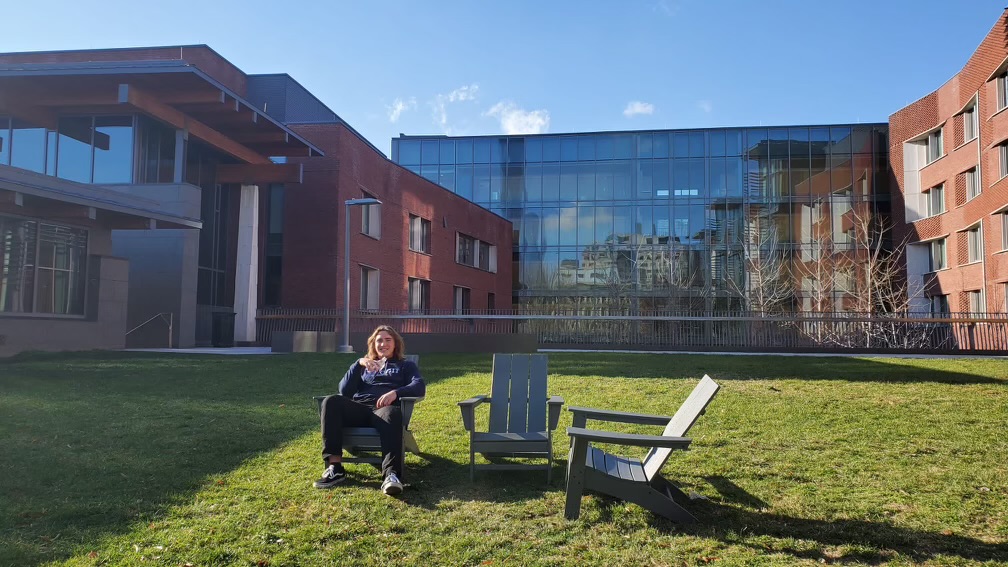 Sebastion takes a seat outside, while enjoying the enjoying the bright sun outside the Lauder Hall.