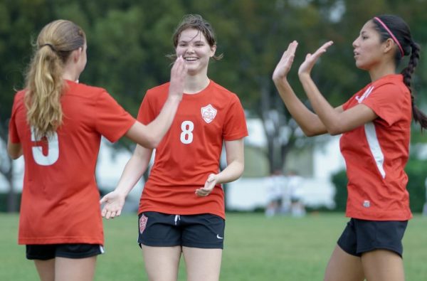 Senior Lenox Balzebre shares a remarkable moment of celebration alongside two of her teammates after a goal is scored during her last home game.