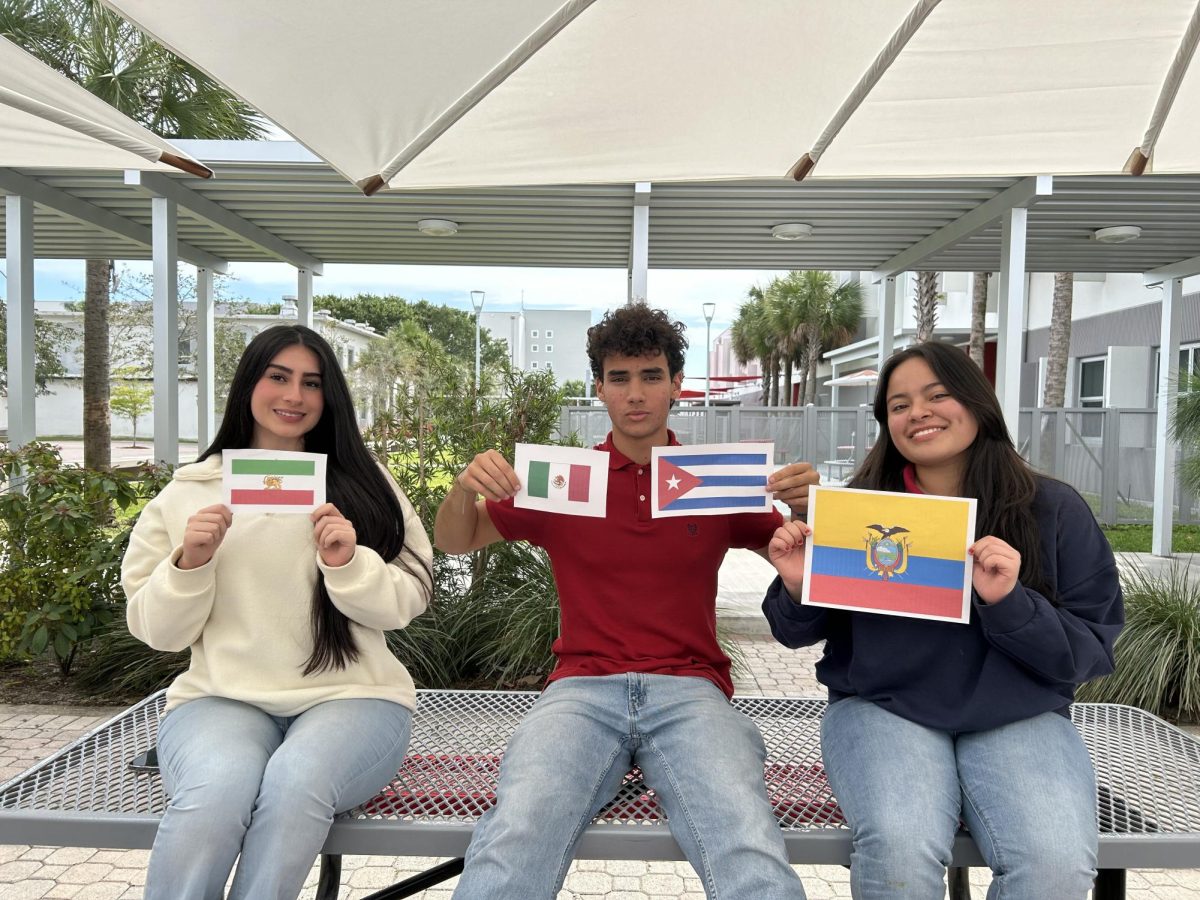 Students+pose+with+the+flags+that+represent+three+unique+stories+from+their+experience+up+to+now.