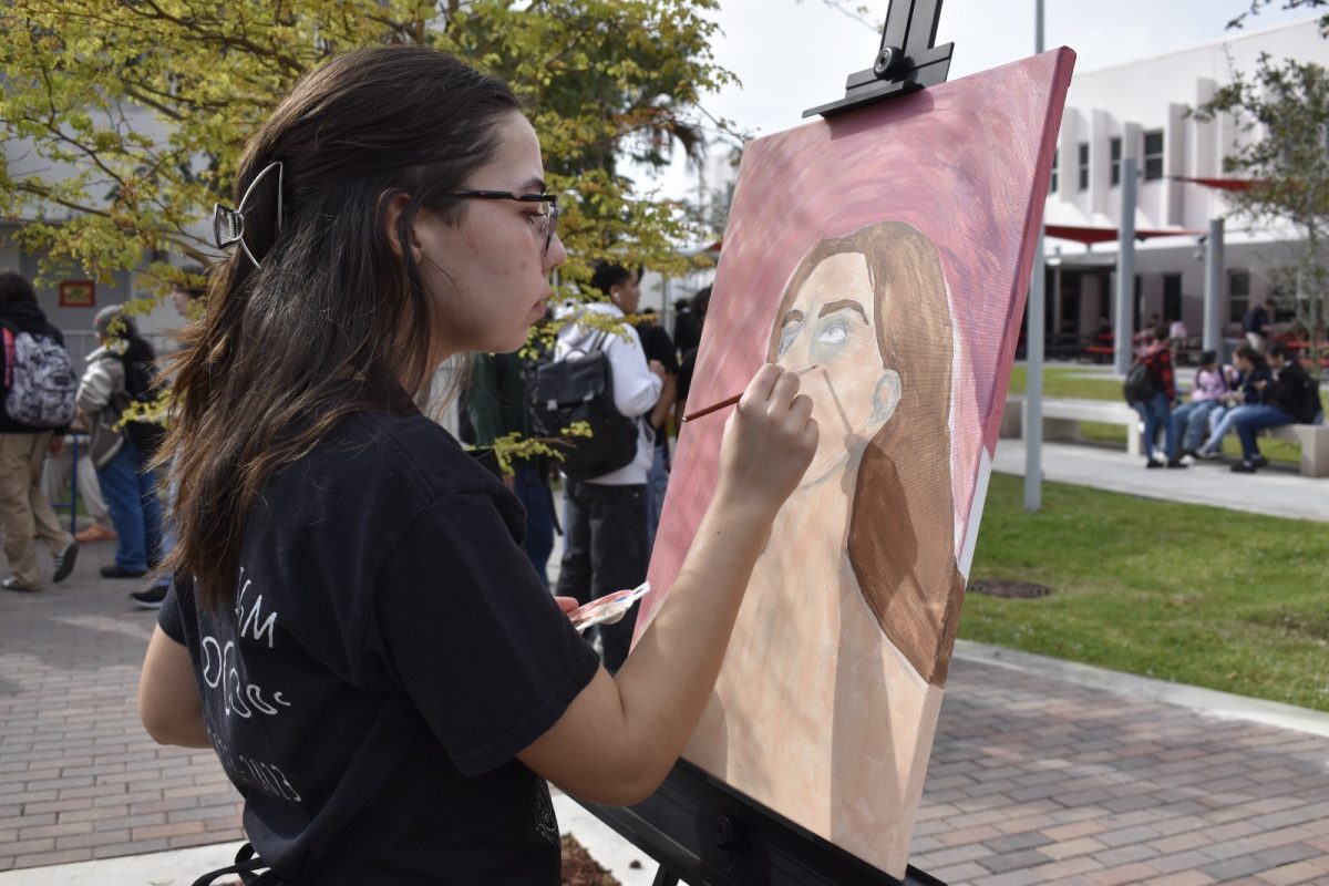 Anderson applied finishing touches on their acrylic painting.