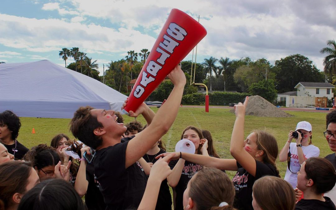 Santiago Giraldo, member of Highlights, chants with his team using a Gables megaphone, boosting their morale and spirit. 