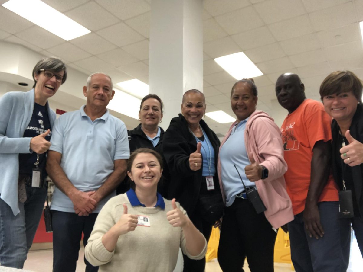 A mix of a Lady Green representative, custodial staff and a PTSA parent gather around for a celebratory photo, finally making their green aspirations come to life.