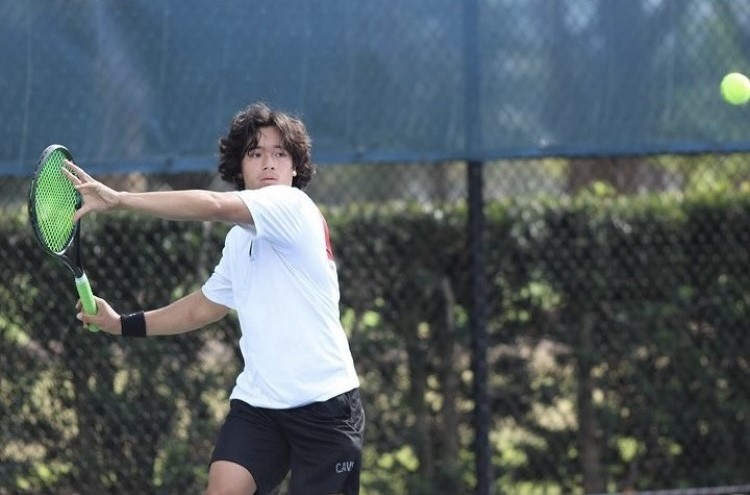 With a powerful right hand stroke, Miller defends his side of the court against a player from South Dade High School. 