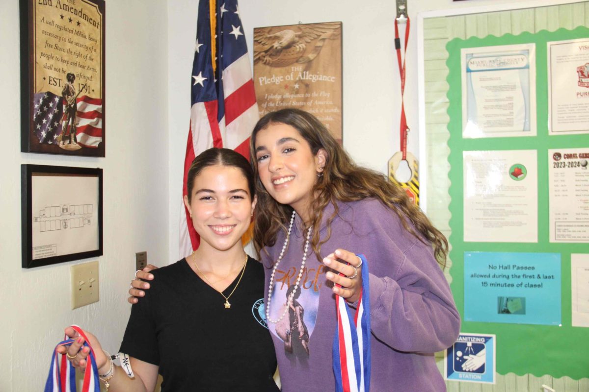 Sara Lecon and Naomi Galex stand proudly with their speech and debate medals. They someday hope to earn a trophy.