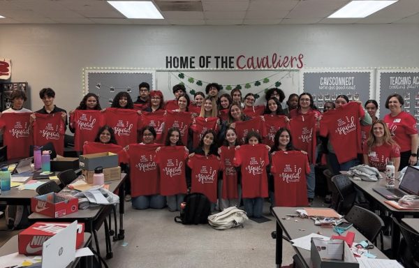 The Teaching Academy gathers around eagerly showing off the shirts personally delivered to them from Miami-Dade College.