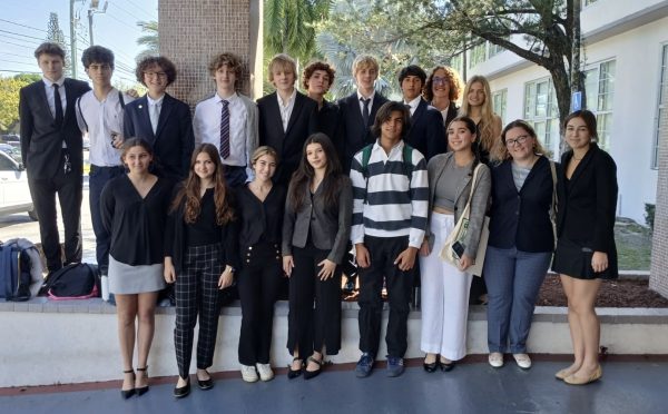 The Gables Model United Nations team poses in front of the school before their bus ride to the conference. The representatives follow a formal dress code and wear suits and formal attire. 