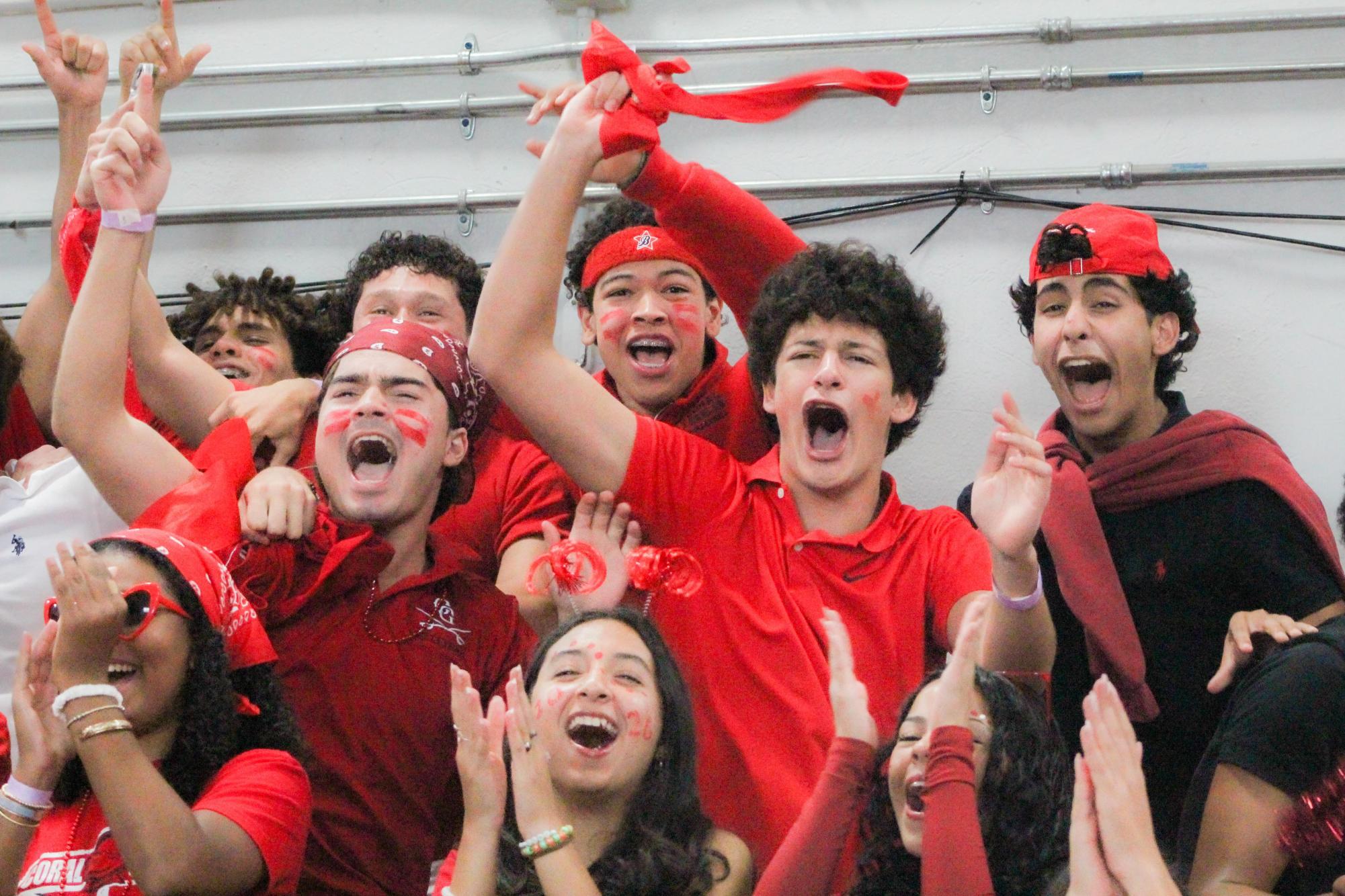 Students celebrate the annual red-out pep rally by cheering for their peers and showing off their pride in full red attire. 