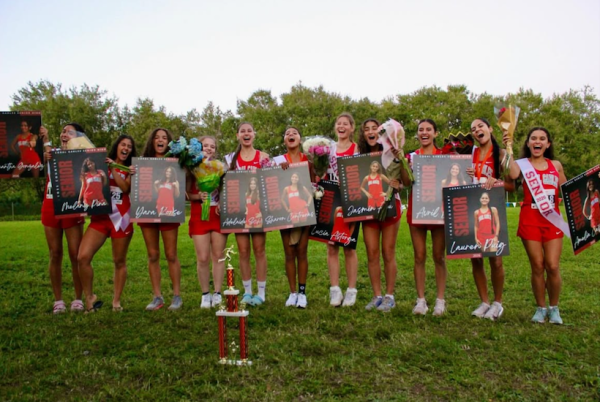 Las seniors del equipo femenino de cross country posan con sus respectivos carteles luego de un exitoso encuentro.